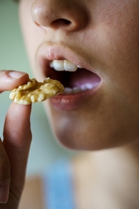 Crop anonymous teenage girl about to eat delicious walnut