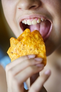 Anonymous girl about to eat spicy tortilla chips at home