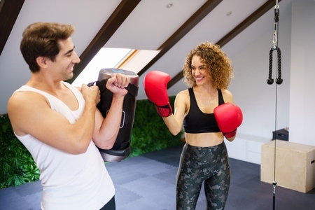 Cheerful fitness buddies boxing in gym