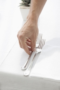 Close up of Waiter039 s Hand Arranging Cutlery on Restaurant Table