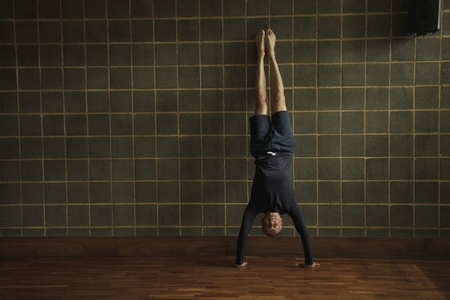 Mature Man Practicing Yoga Handstand