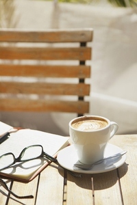 Cappuccino Eyeglasses and Notepad on Outdoors Table