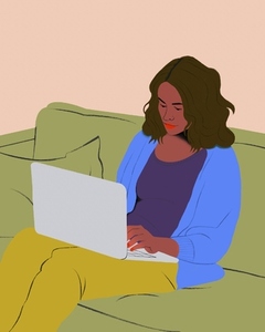 Woman working from home at laptop on living room sofa