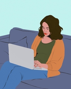 Young woman working from home at laptop on living room sofa
