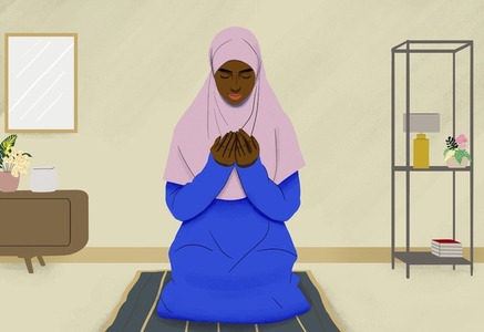 Muslim woman praying on mat in living room at home