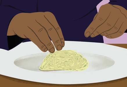 Close up hands of chef plating pasta on plate