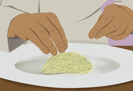 Close up hands of chef plating pasta on plate