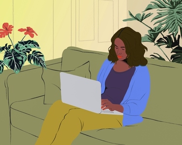 Woman with laptop working from home on living room sofa