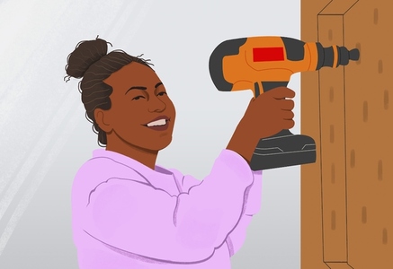 Portrait happy woman using power drill on DIY project