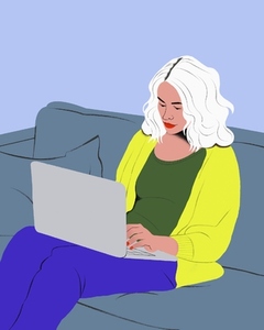 Woman with white hair working from home at laptop on living room sofa