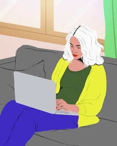Woman with white hair working from home at laptop on living room sofa