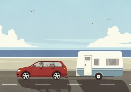 Family on vacation in car pulling camper trailer along sunny summer ocean beach