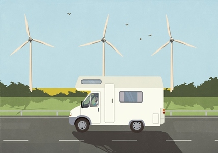 Man on vacation driving camper along wind turbines in sunny countryside