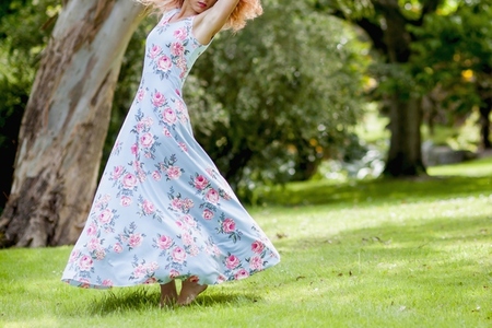 Woman in Floral Dress Dancing in Garden
