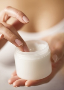 Close up of a woman039 s hands holding an open jar of cosmetic cream