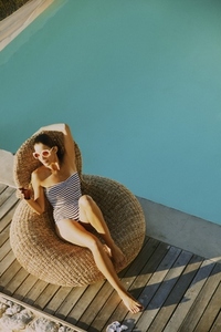 Woman Relaxing by Swimming Pool