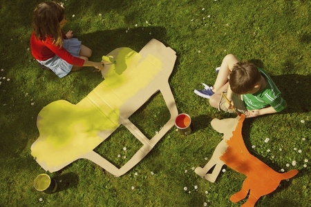 Children Painting Cardboard Cut Outs in Garden
