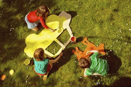 Children Painting Cardboard Cut Outs in Garden