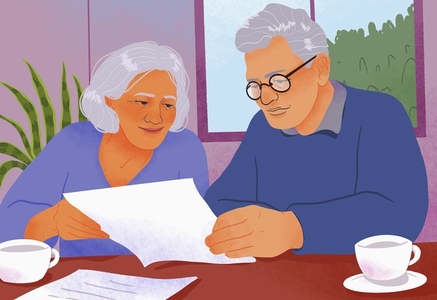 Senior couple paying bills reviewing paperwork at home