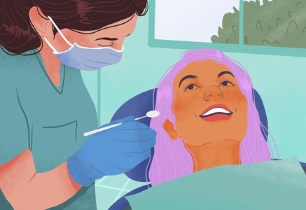 Smiling woman talking to dental hygienist during teeth cleaning