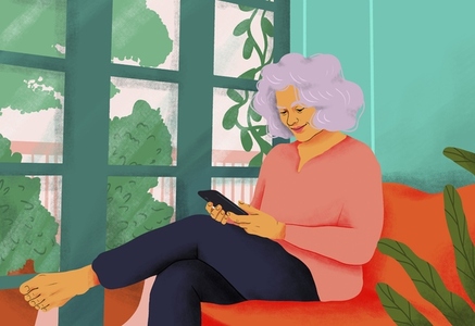 Happy serene senior woman using smart phone on sofa at home