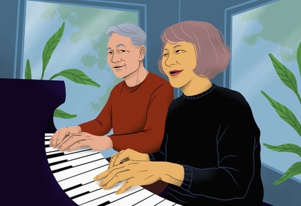 Happy senior couple playing piano together at home