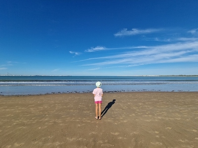 Girl with hat in front of the sea  on a sandy beach  Valdelagrana Beach