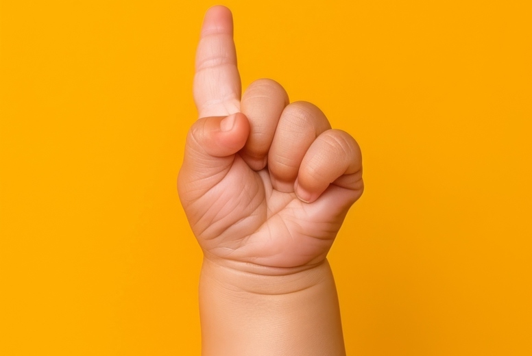 The hand of a small child shows one finger up