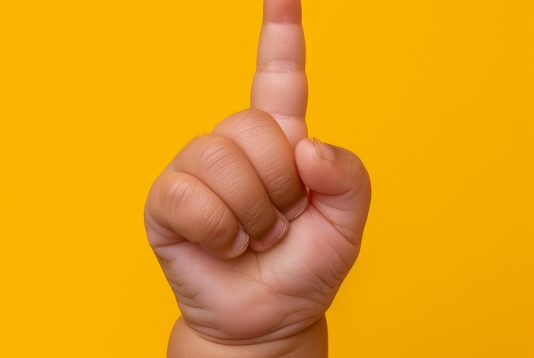 The hand of a small child shows one finger up