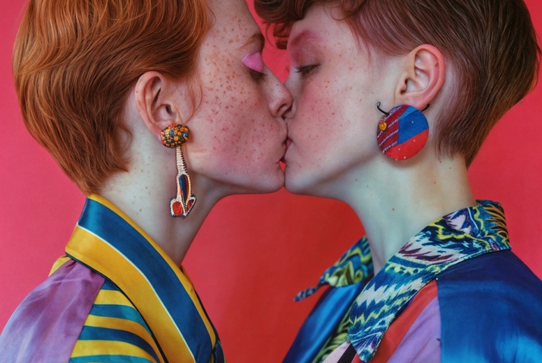 Two young women kiss
