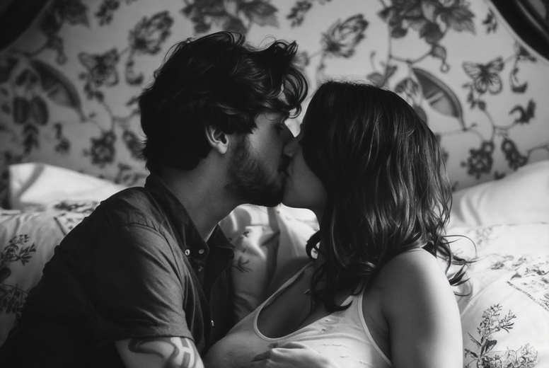 Romantic couple in love kissing in bed