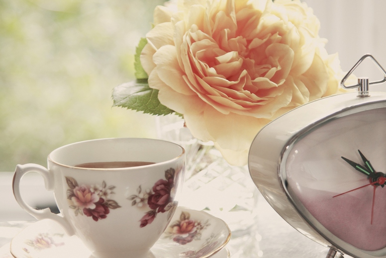 Teacup, Clock, Jewelry and Flowers on Woman's Dressing Table