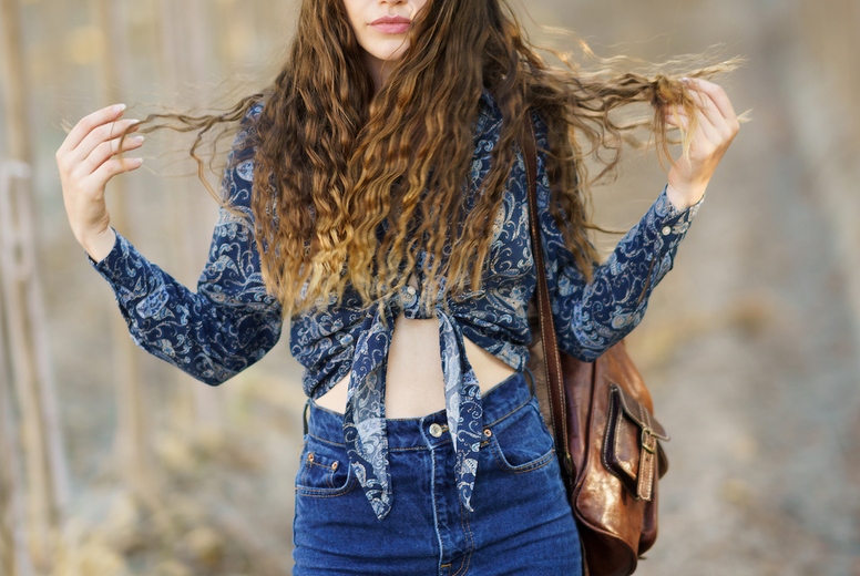 A Trendy Young Woman Dressed in a Stylish Outfit Joyfully Enjoys Nature Surrounded by a Vineyard