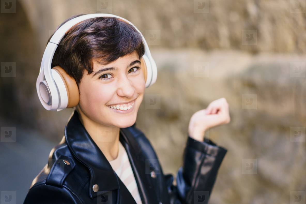 A Young Person Happily Enjoying Their Favorite Music While Wearing Headphones in an Urban Setting
