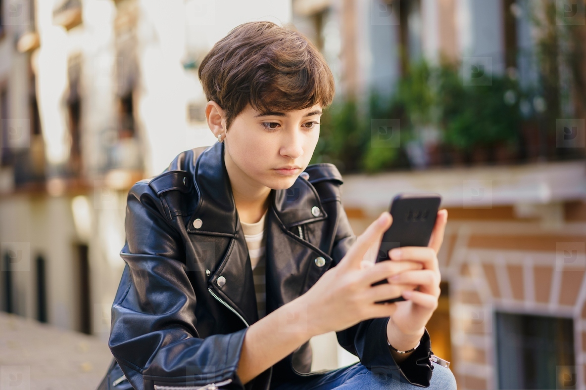 A teenage girl absorbed in her mobile phone in a vibrant urban setting  candidly captured