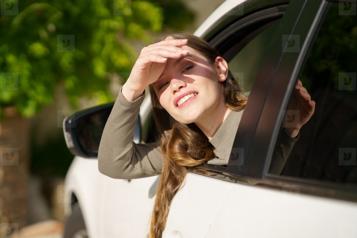 A Young Woman Happily Enjoying the Warm  Sunny Day While Looking Out From a Car Window