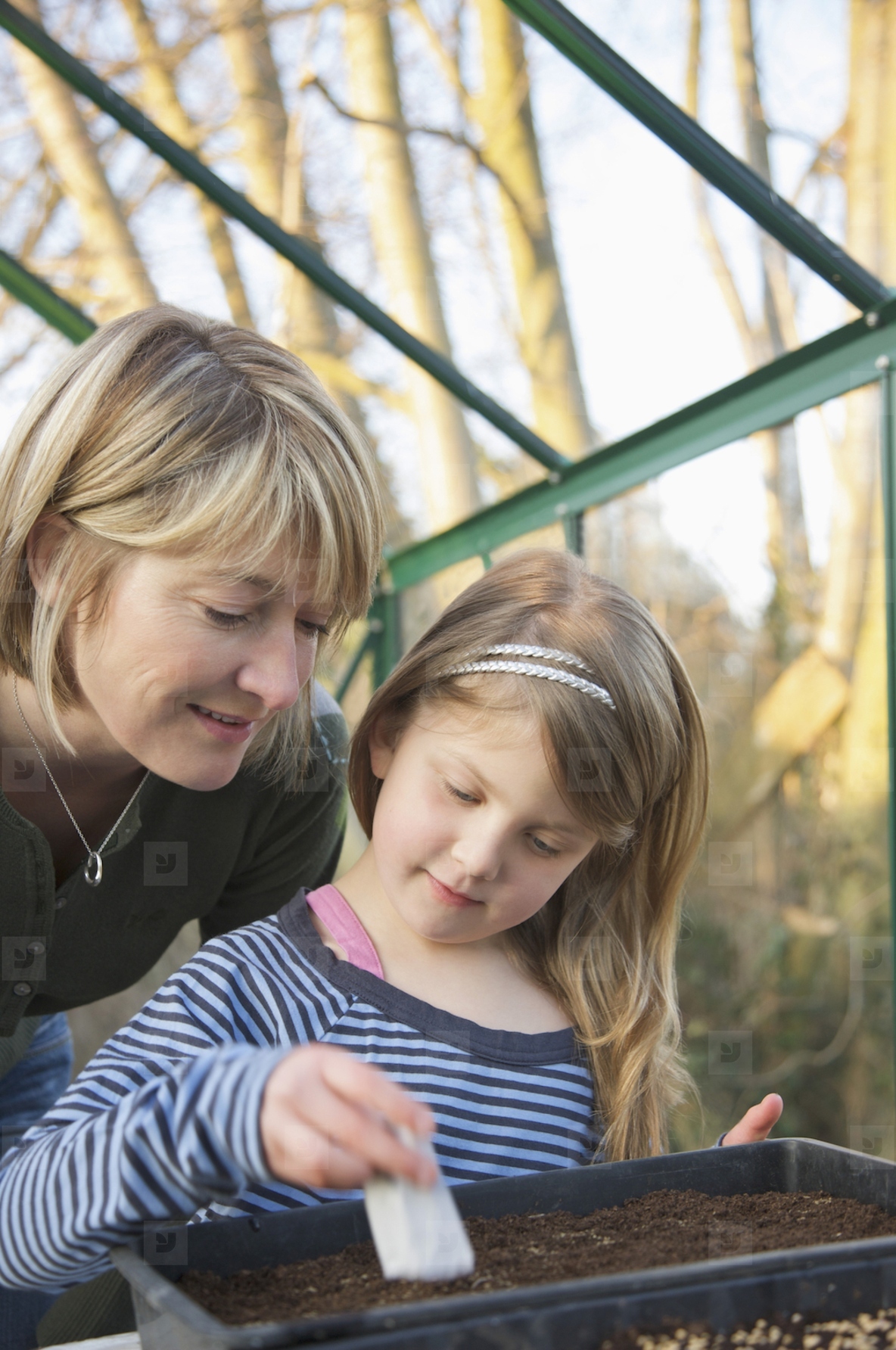 Close up of mother and daughter planting seeds