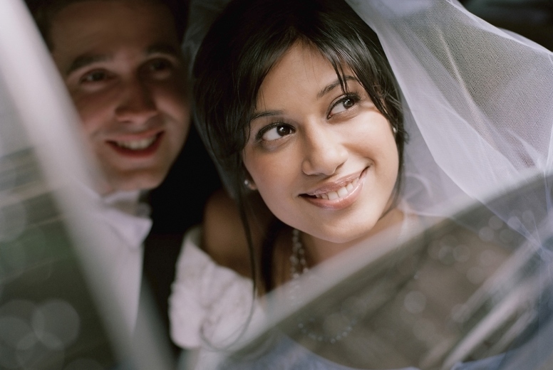 Bride and groom sitting inside a car