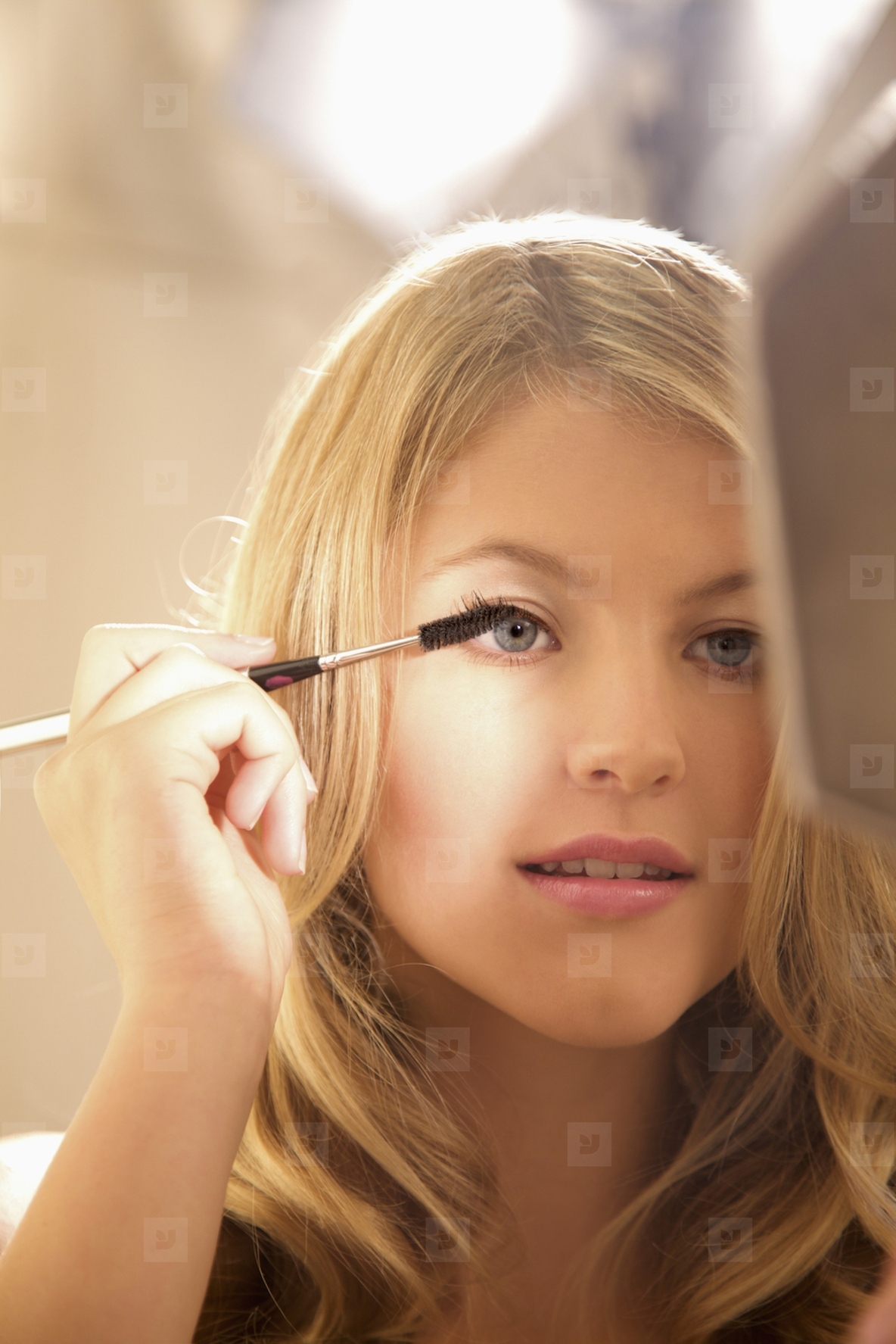 Close up of a young woman applying mascara