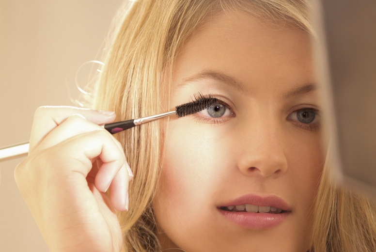 Close up of a young woman applying mascara