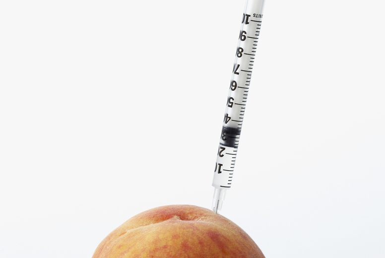 Hypodermic Needle Inserted in a Peach