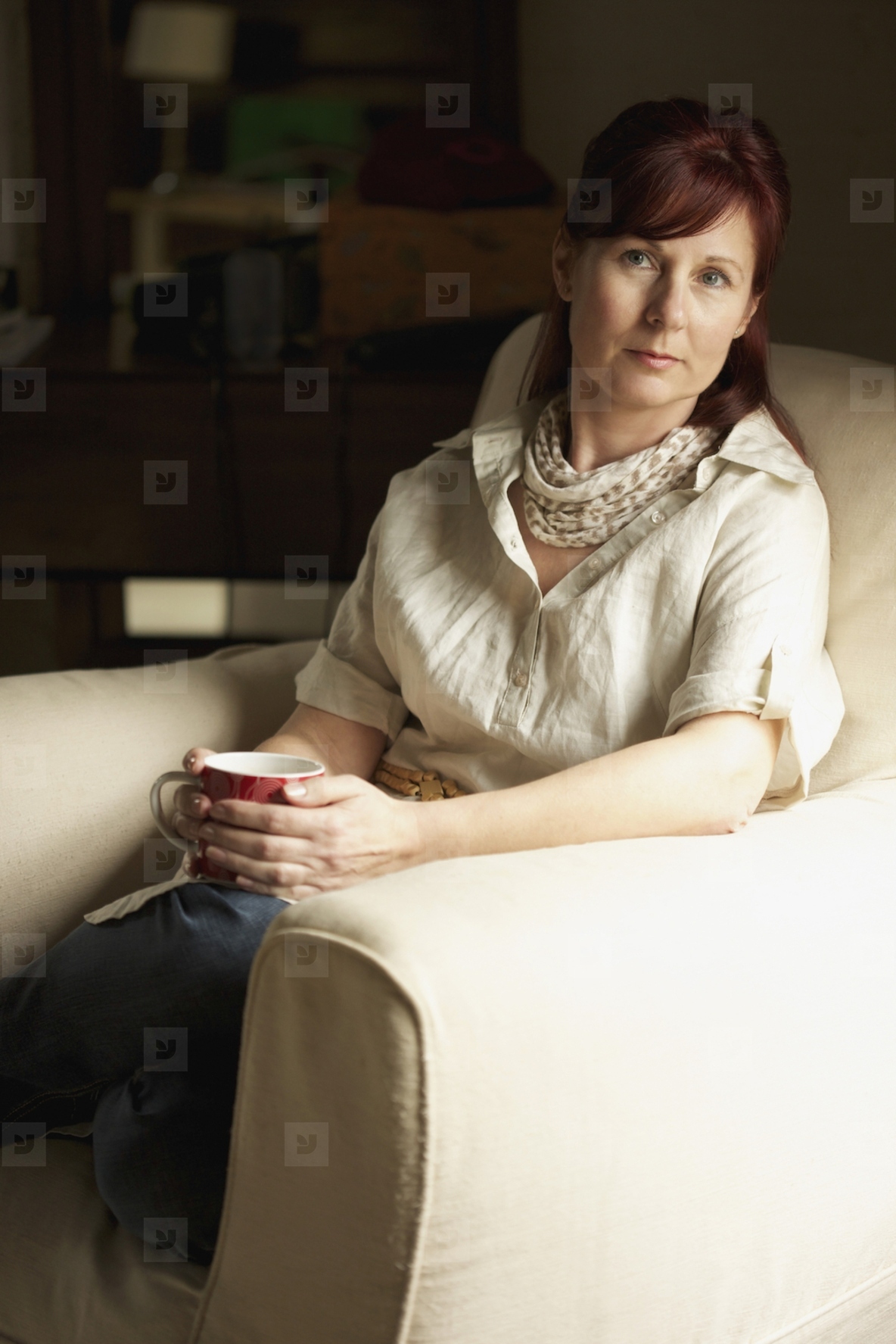 Woman Sitting on Armchair Holding Coffee Cup