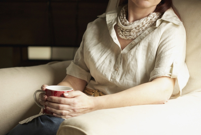 Woman Sitting on Armchair Holding Coffee Cup