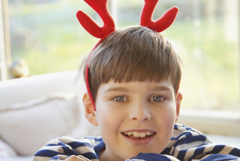 Smiling Boy Wearing Christmas Antlers