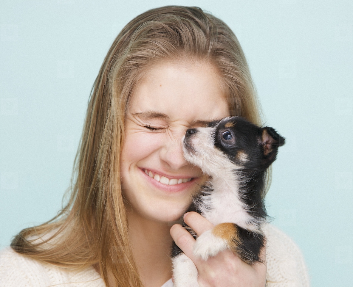 Smiling Teenage Girl Hugging Tiny Puppy