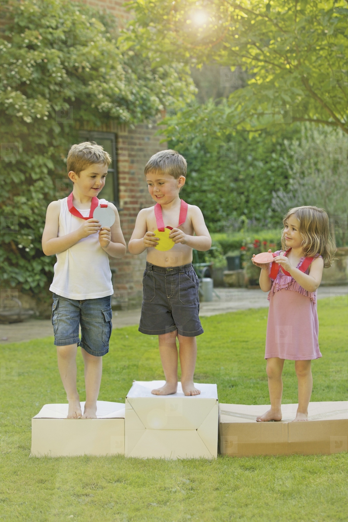 Children Standing on Cardboard Podium with Medals