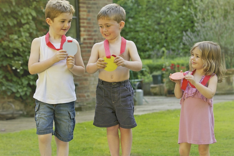 Children Standing on Cardboard Podium with Medals