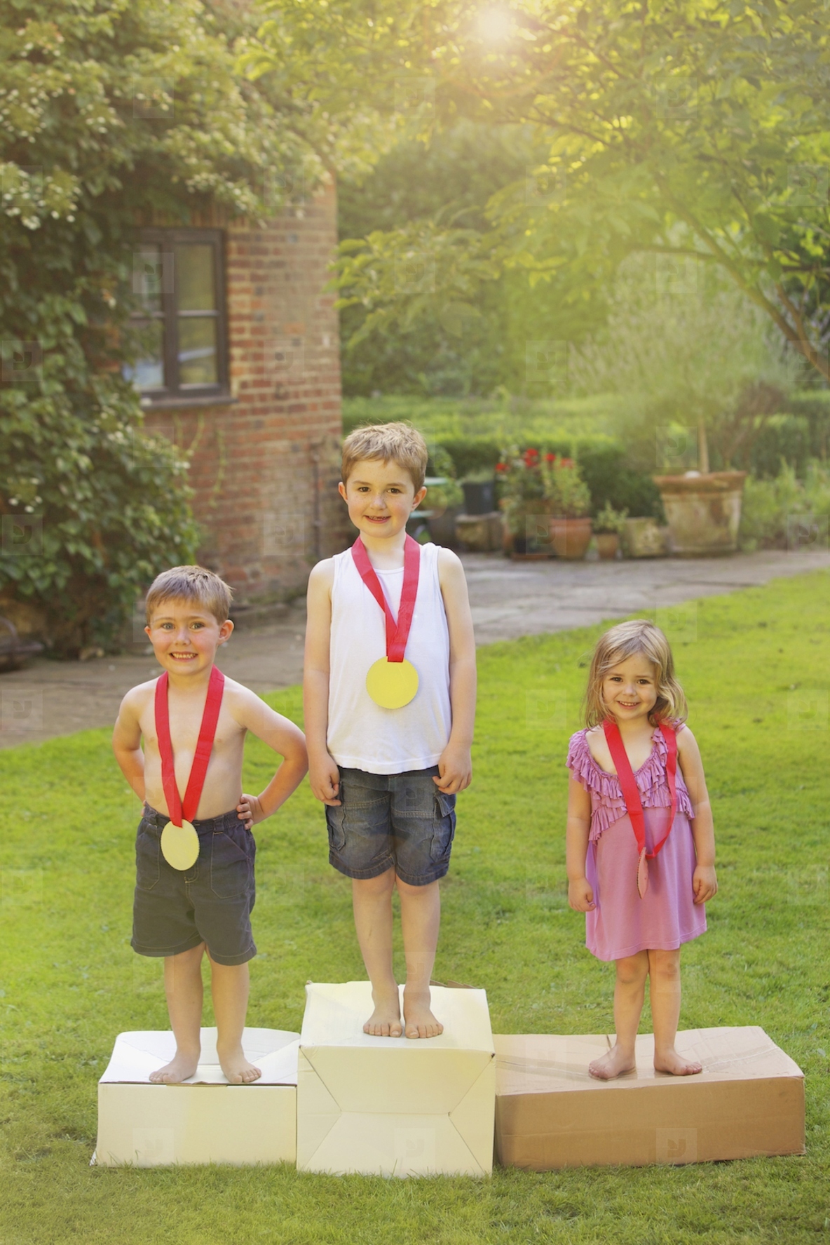 Children Standing on Cardboard Podium with Medals