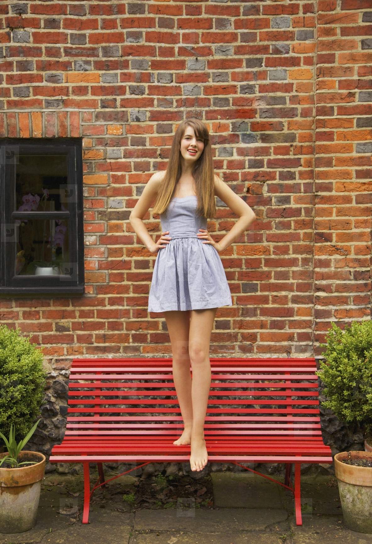 Teenage Girl Standing on Red Bench