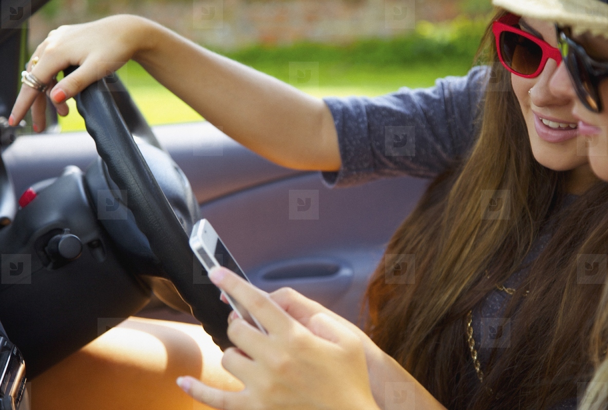 Teenage Girls Using Cell Phone Inside Car